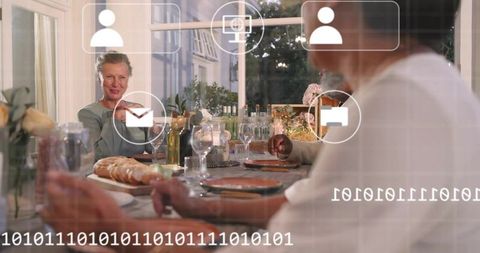 Senior woman gesturing at dinner table with smart home ui overlay, intimate family gathering