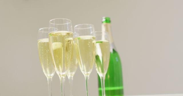 Image of champagne in glasses and bottle on beige background. alcohol, beverage, drinks, party and celebration concept.