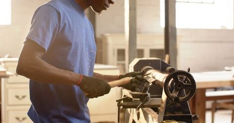 Skilled woodworker crafting wood on lathe in workshop setting