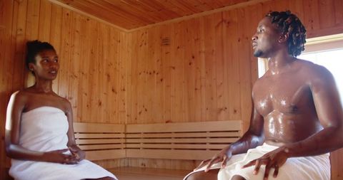 African american couple relaxing in wooden sauna towels wellness intimacy spa retreat