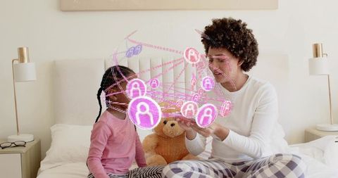 Mother and daughter interacting with glowing holographic network while wearing pajamas