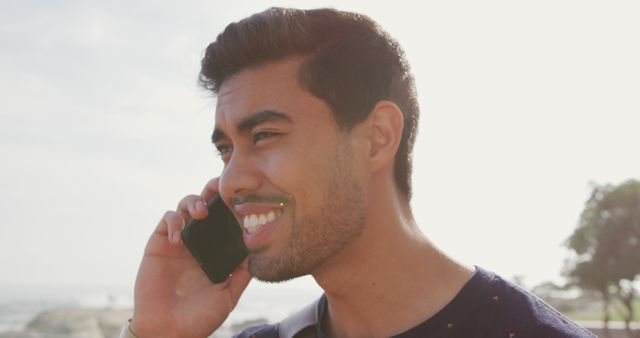 Smiling Young Man Talking on Smartphone Outdoors - Download Free Stock Images Pikwizard.com