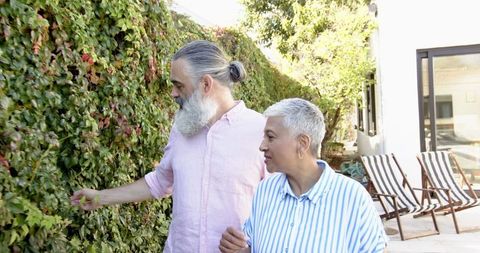 Senior couple exploring patio garden with lush vines
