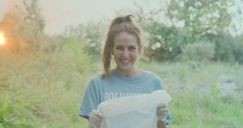 Smiling Eco Volunteer Holding Recycled Plastic Bag in Nature