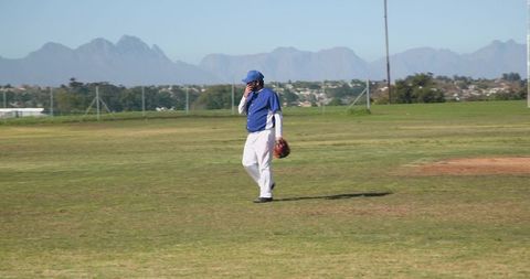 Baseball Player Strolling Across Sunlit Field