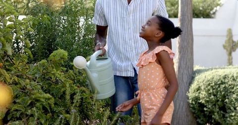 Father and Daughter Bonding While Watering Garden Plants