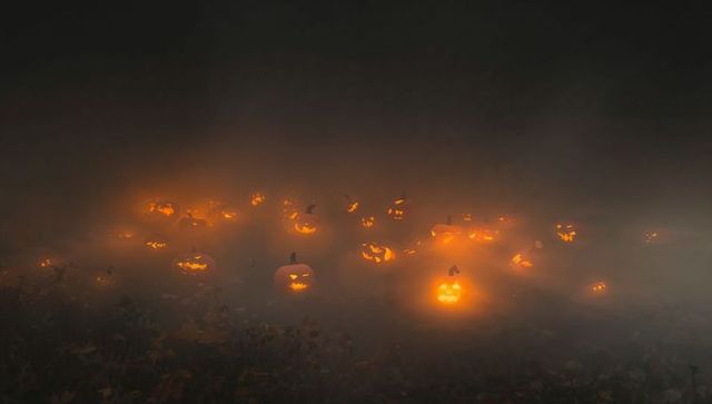Glowing jack-o'-lanterns in misty field creating spooky atmosphere