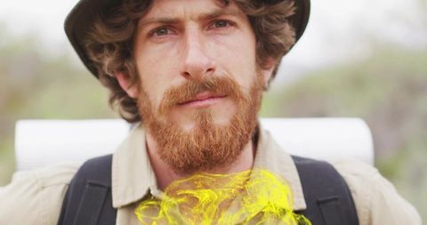 Hiker in wide-brimmed hat with vibrant yellow smoke