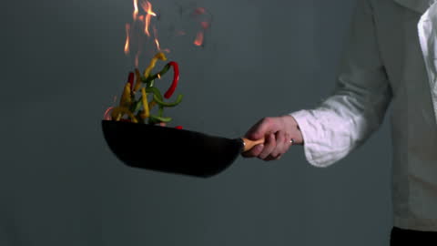 Chef Flipping Colorful Peppers in Fiery Stir Fry