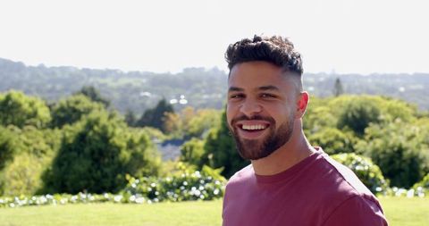 Smiling Man Enjoying Relaxation in Sunny Hillside View