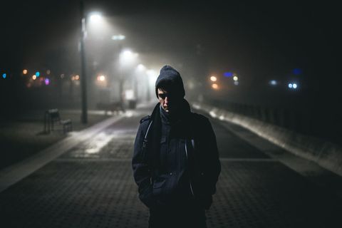 Person Standing in Foggy Night Street with Embedded Lights