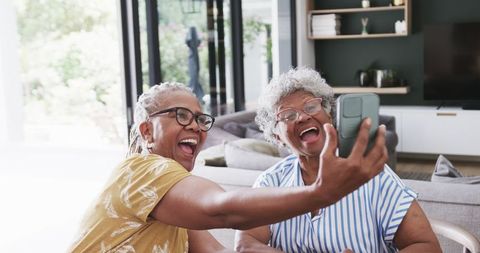 Joyful Senior Women Taking Selfie Together at Sunny Home
