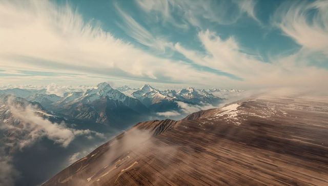 Panoramic view of majestic mountain ridge with blue sky clouds