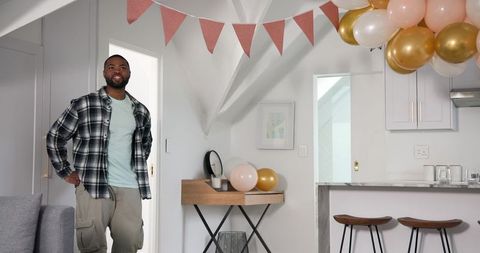 Man preparing anniversary party with balloons and decorations
