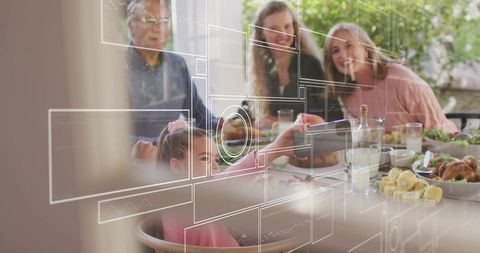 Multigenerational family sharing meal using smartphone with holographic interface outdoor