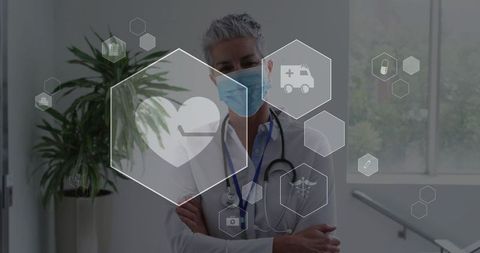 Standing senior doctor wearing mask and stethoscope in clinic with digital medical hex icons