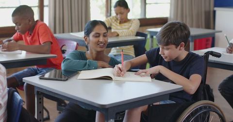 Inclusive Education Classroom: Teacher Assists Student in Wheelchair - Download Free Stock Images Pikwizard.com
