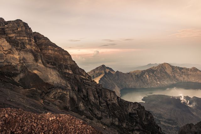 This stunning image captures the serene beauty of a volcanic mountain range at sunrise, offering a breathtaking panoramic view perfect for travel promotions, nature blogs, adventure magazines, and backgrounds in presentations.