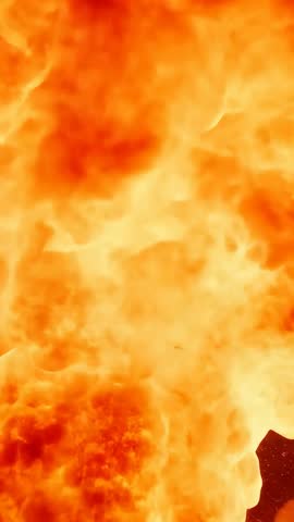 Detonating mushroom cloud rising from horizon, pushing glowing plumes and embers in vertical video