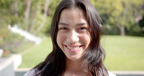 Smiling teenage girl in sunlit garden