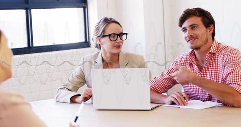 Team collaboration: woman in blazer and man in checked shirt discussing at laptop