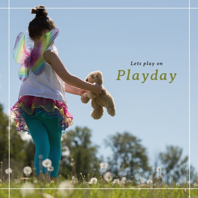 Image shows a young girl wearing colorful fairy wings, playing with a teddy bear in a grassy field on a sunny day. Cover image for kids' activities, summer, fairy tales, imagination, and playful moments promotions.