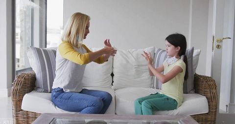 Mother and daughter engaged in sign language communication at home