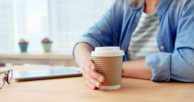 Close-Up of Person Holding Coffee Cup in Modern Office - Download Free Stock Images Pikwizard.com