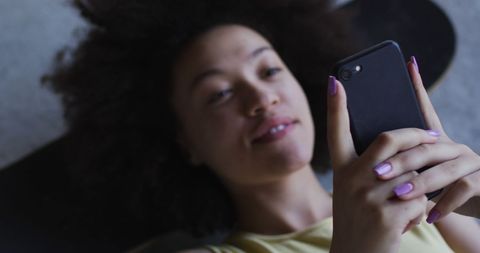 Woman relaxing on skateboard using smartphone