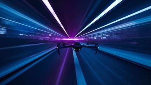 Flying quadcopter drone racing through neon tunnel with camera gimbal in motion