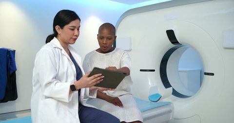 Clinician reviewing ct scan results with female patient by modern ct scanner