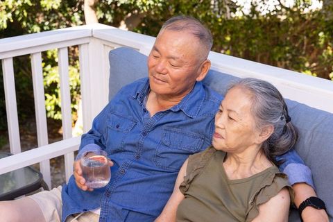 Senior asian couple relaxing on deck bench enjoying quiet outdoor moment