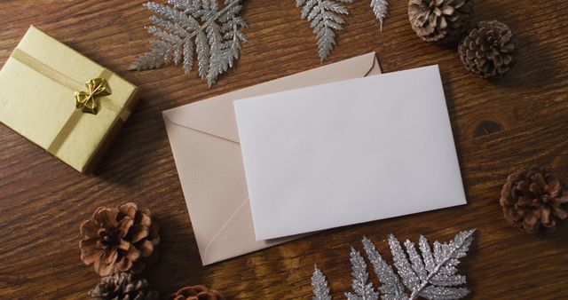 Image of christmas decorations with white card and beige envelope on wooden background - Download Free Stock Photos Pikwizard.com