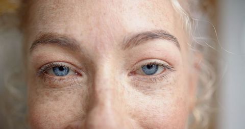 Close-Up of Blue Eyes and Freckles, Showcasing Natural Beauty