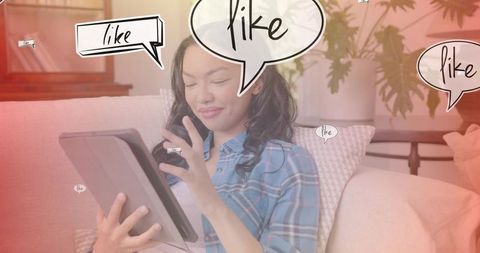 Woman tapping tablet on couch surrounded by social media like bubbles and cozy living room
