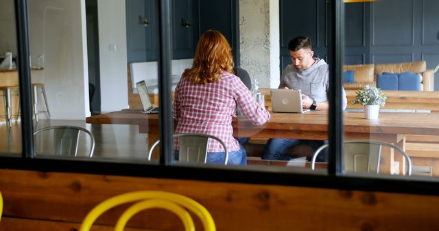 Modern Workspace with Two People Collaborating at Table - Download Free Stock Images Pikwizard.com