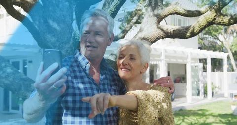 Joyful Mature Couple Taking Selfie in Scenic Backyard Setting