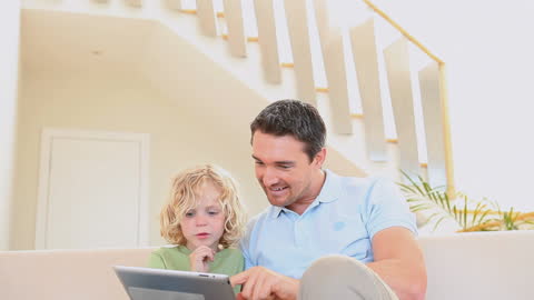 Father and Son Bonding with Digital Tablet in Bright Living Room