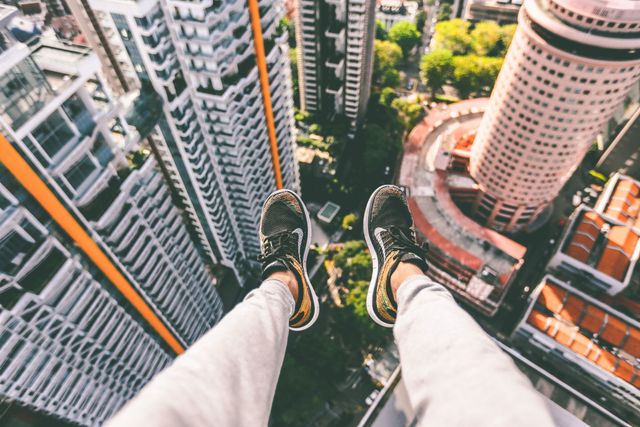 Legs Dangling Above Cityscape From High-rise Building - Download Free Stock Photos Pikwizard.com