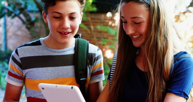 Teenagers Using Tablet Outdoors Smiling and Bonding - Download Free Stock Images Pikwizard.com