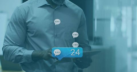 Mature professional holding tablet checking 24 chat notifications in modern office