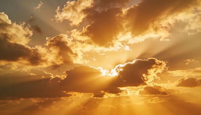 Sunrise beams piercing clouds, casting golden crepuscular rays across dramatic sky