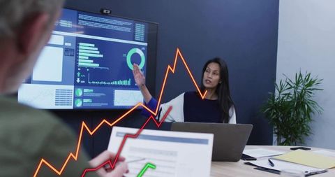 Businesswoman presenting interactive dashboards and analytics during boardroom meeting