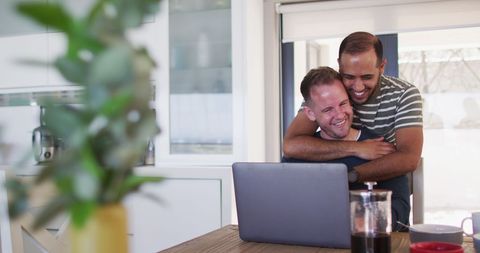 Happy Multiracial Gay Couple Embracing at Home