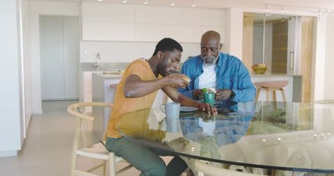 Father and Son Sharing a Meal at Home Kitchen Dining Table