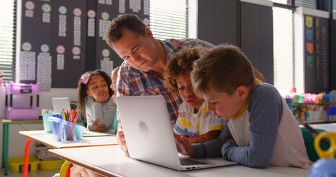 Enthusiastic Teacher Helping Curious Children with Technology