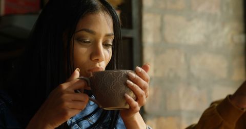 Woman Savoring Warm Beverage by Window in Casual Outfit - Download Free Stock Images Pikwizard.com
