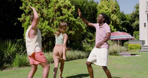 Friends socializing in garden under colorful umbrella