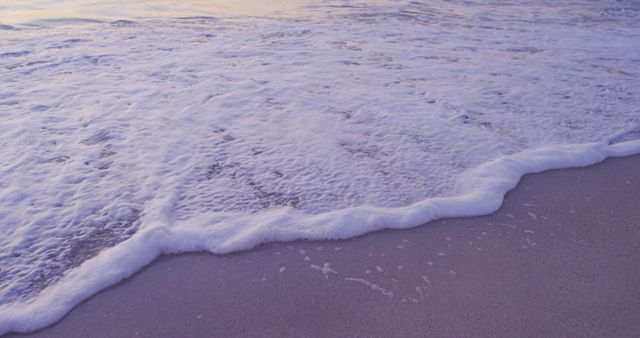 High angle of a sandy beach and calm sea at sunset, shot in slow motion 
