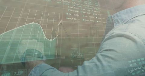 Businessman analyzing holographic financial dashboard over office desk
